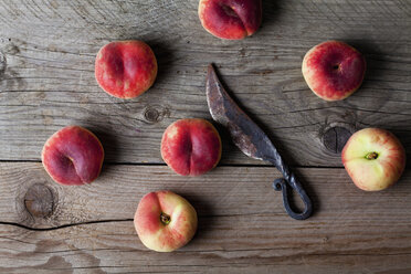 Doughnut peaches and old rusty knife on wood - CSF025741