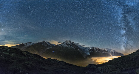 France, Mont Blanc, Lake Cheserys, Milky way and Mount Blanc by night with the valley lighted by the lights of the town of Chamonix - LOMF000007