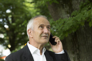 Porträt eines Geschäftsmannes, der mit einem Smartphone telefoniert - SGF001710