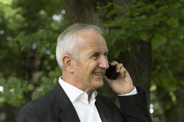 Porträt eines Geschäftsmannes, der mit einem Smartphone telefoniert - SGF001711