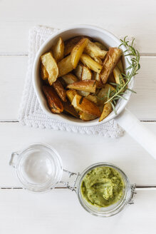 Auflauf von Kartoffelspalten mit Rosmarin und einem Glas Pesto - EVGF001824