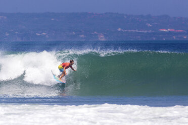 Indonesien, Bali, Mann surft auf einer Welle - KNTF000133