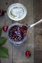 Jar of cherry jam and cherries on wood - LVF003542