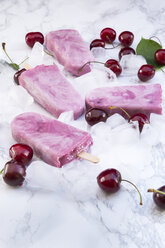 Cherry yoghurt ice lollies and cherries on white marble - LVF003566