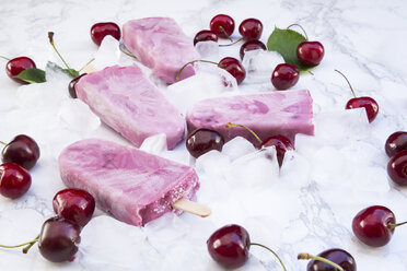 Cherry yoghurt ice lollies and cherries on white marble - LVF003565