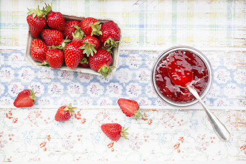 Glas Erdbeermarmelade und Schachtel mit Erdbeeren, lizenzfreies Stockfoto