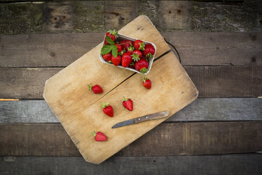 Box of strawberries and kitchen knife on wood - LVF003553