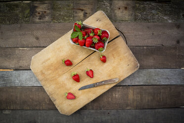 Kiste mit Erdbeeren und Küchenmesser auf Holz - LVF003553
