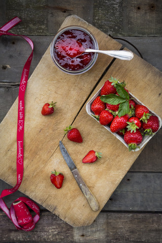 Glas hausgemachte Erdbeermarmelade, Schleife und Schachtel mit Erdbeeren, lizenzfreies Stockfoto