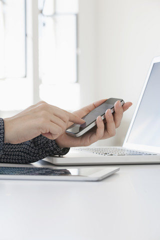 Nahaufnahme der Hände einer Frau beim Benutzen eines Smartphones, lizenzfreies Stockfoto