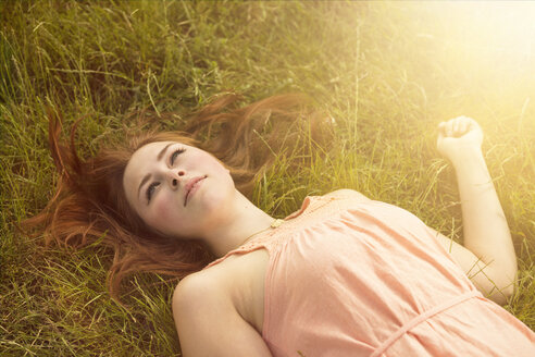 Daydreaming woman lying on a meadow - TAM000152