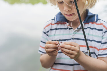 Germany, Boy preparing fishing rod - MJF001536