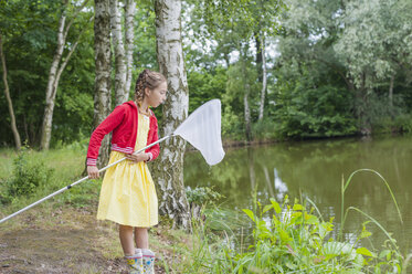 Germany, Girl with fishing net at pond - MJF001538