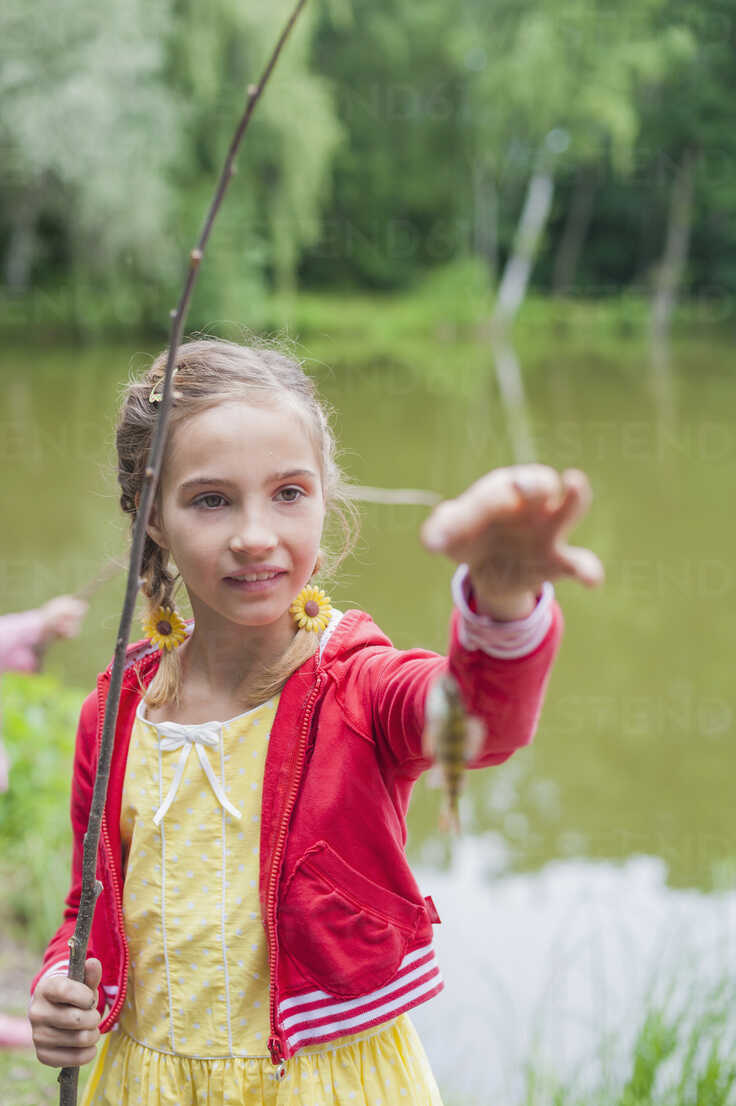 Germany, Girl with rod and small fish stock photo