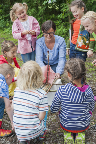 Deutschland, Kinder lernen, wie man ein Holzfloß baut, lizenzfreies Stockfoto