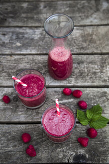 Roter Smoothie in Gläsern, Himbeeren auf Holz - SARF001989