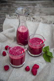 Roter Smoothie in Gläsern, Himbeeren auf Holz - SARF001990