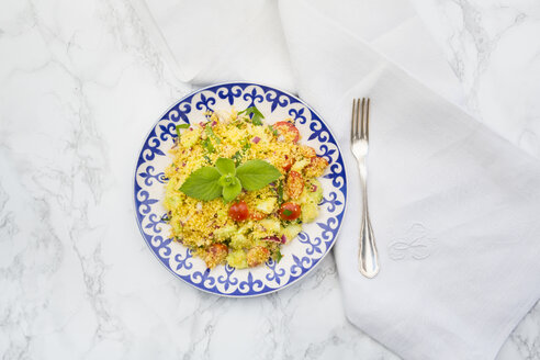 Teller mit Couscous-Salat, Tuch und Gabel auf weißem Marmor - LVF003598