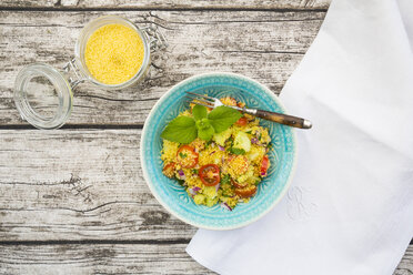 Plate of couscous salad, cloth and glass of couscous on wood - LVF003602