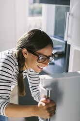 Young woman opening fridge door - EBSF000690