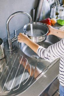 Frau gießt Wasser in einen Kochtopf - EBSF000691