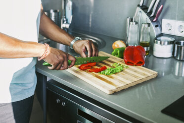Junger Mann schneidet Gemüse in seiner Küche - EBSF000693