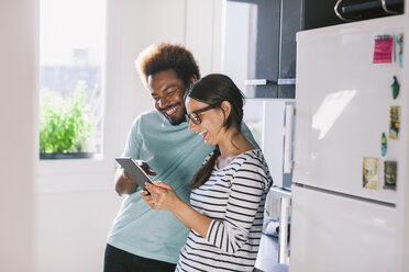 Happy young couple having fun in their kitchen - EBSF000695