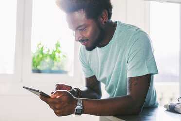 Junger Mann benutzt sein Phablet zu Hause - EBSF000697