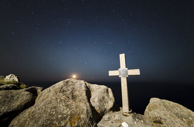 Spain, Galicia, Ferrol, Moonset in a place of the galician coast with a stone cross on the foreground - RAE000220