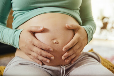 Pregnant woman holding her belly, close-up - MFF001673