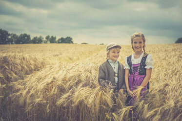 Deutschland, Sachsen, zwei Kinder stehen in einem Getreidefeld - MJF001578