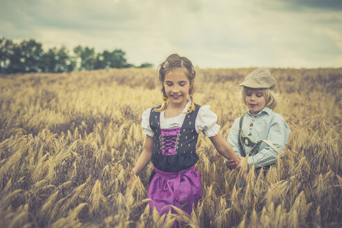 Germany, Saxony, boy and girl walking in a grain field - MJF001594