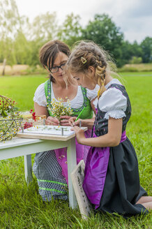 Deutschland, Sachsen, Mädchen im Dirndl lernt Pflanzen zu zeichnen - MJF001609