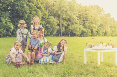 Deutschland, Sachsen, Gruppenbild von Kindern in traditioneller Kleidung und ihrer Erzieherin auf einer Wiese - MJF001627