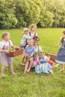 Deutschland, Sachsen, Kinder und ihre Erzieherin in traditioneller Kleidung auf einer Wiese - MJF001619