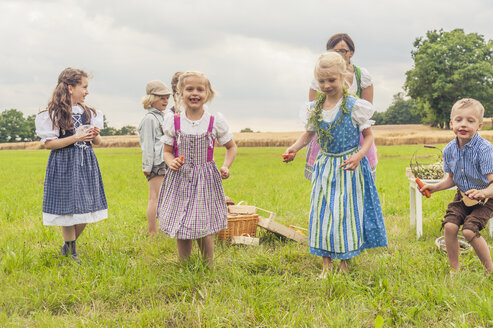 Deutschland, Sachsen, Kinder in traditioneller Kleidung tanzen auf einer Wiese - MJF001628