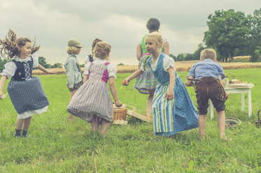 Deutschland, Sachsen, Kinder in traditioneller Kleidung tanzen auf einer Wiese - MJF001629