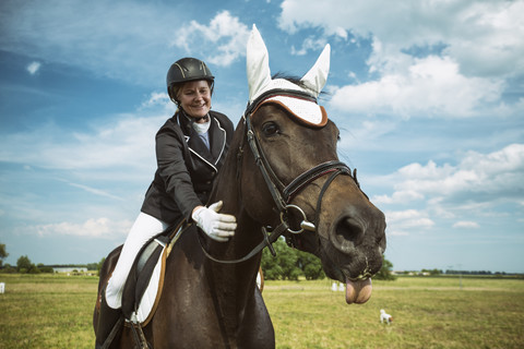 Lächelnde Reiterin auf Pferd, lizenzfreies Stockfoto