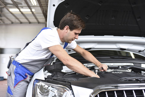 Mechaniker repariert Auto in einer Werkstatt, lizenzfreies Stockfoto