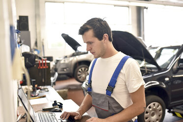 Automechaniker mit Laptop in einer Werkstatt - LYF000436