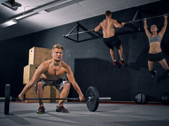 Three CrossFit athletes at workout - MADF000359