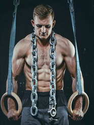 Porträt eines CrossFit-Sportlers, der Gymnastikringe benutzt - MADF000325