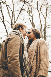 Young couple in love standinmg face to face in an autumnal park - CHAF000220