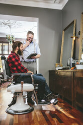 Barber with customer using digital tablet - MADF000333