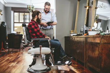 Barbier mit Kunde über digitales Tablet - MADF000334