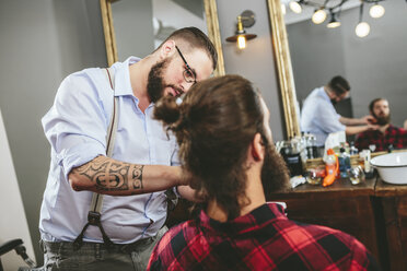 Friseur bürstet den Bart eines Kunden - MADF000337