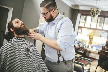 Barbier schneidet Bart eines Kunden - MADF000346
