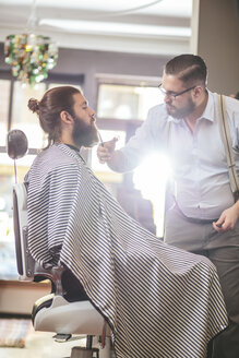 Barbier schneidet Bart eines Kunden - MADF000348