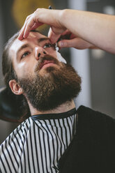 Mann mit Vollbart lässt sich beim Friseur rasieren - MADF000349