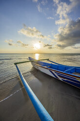 Indonesien, Bali, Jimbaran, Traditionelles Fischerboot am Strand bei Sonnenuntergang - THAF001398